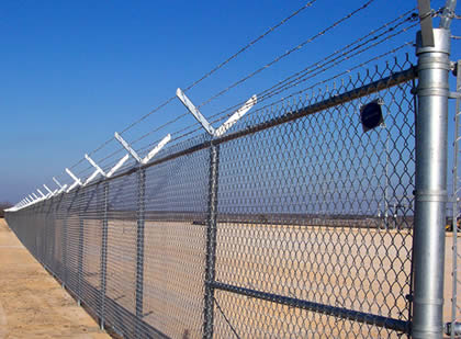 Six barbed wires mounted on chain link fence