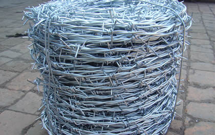 A roll of double twist galvanized barbed wire on the brick ground