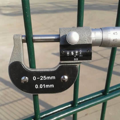 A worker is measuring the vertical wire diameter of twin wire fence by micrometer.